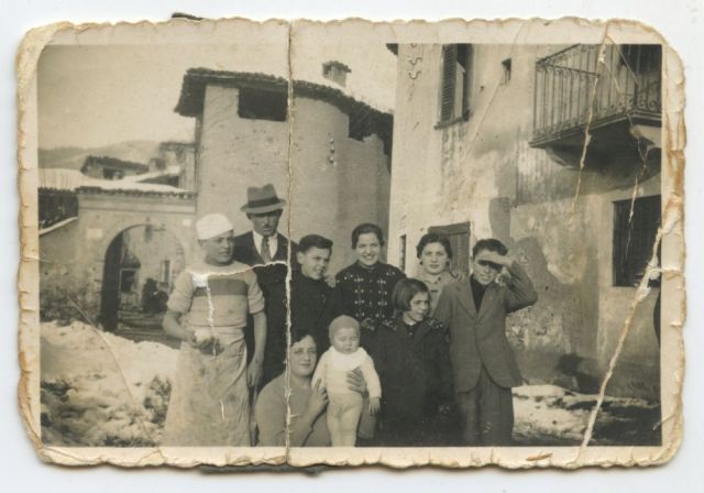 Cadestore, frazione di Villa d’Adda, 1938 – Il bambino sulla sinistra con una pagnotta in mano è Carlo, scomparso in Russia nel 1943. Alla destra di Giuseppe (il terzo da sinistra) c’è il padre Camillo. Alla sua sinistra la sorelle Teresa, Adele e Anita e il fratello Rizieri. La famiglia viveva nella casa di cui si scorge una parete sulla destra